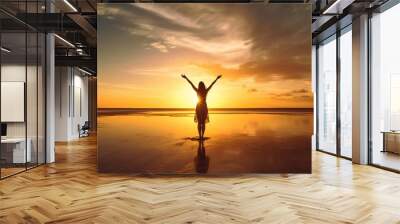 Happy woman with arms up enjoy freedom at the beach at sunset. Wellness, success, freedom and travel concept, silhouette of a girl standing on the beach Wall mural