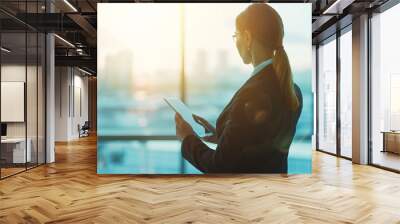 Panoramic banner of a professional businesswoman using a digital tablet in a modern office setting with contemporary technology Wall mural