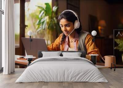 Young Indian woman studying online with laptop and notebook at home office. E-learning and remote work concept. Wall mural