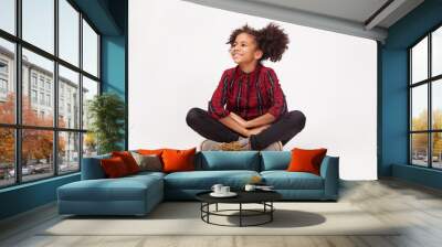 Cute teenage girl in casual stylish clothes sitting against white background Wall mural