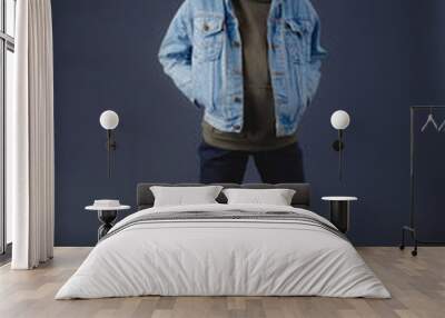 Teenage girl in jean jacket against dark background Wall mural