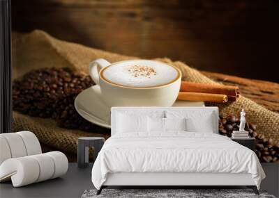 A cup of cappuccino and coffee beans on old wooden background Wall mural