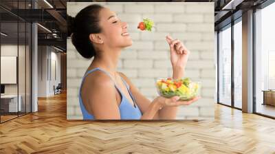 Asian woman in joyful postures with hand holding salad bowl Wall mural