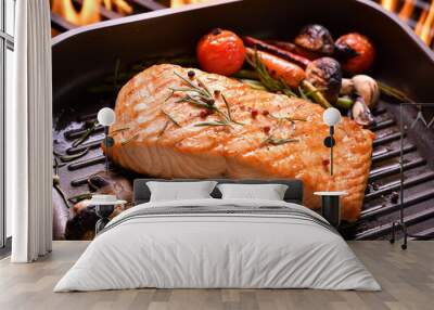 Grilled salmon fish with various vegetables on pan on the flaming grill Wall mural