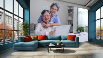 Happy Asian Senior couple at home. Handsome old man and attractive old woman are spending time together. Elderly couple with laptop. Online shopping. Looking at camera. Wall mural