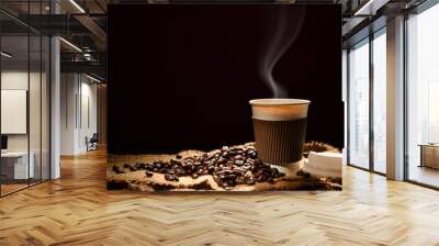 Paper cup of coffee with smoke and coffee beans on black background Wall mural