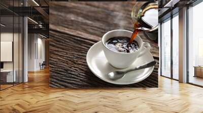 Pouring coffee with smoke on a cup on wooden background Wall mural