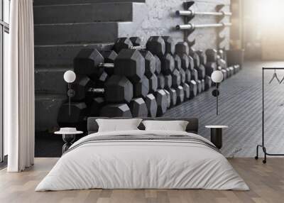 Equipment, gym weights and floor of room or empty facility for fitness, sports and exercise club mockup. Dumbbells, barbell stack and weight rack in a dark training gymnasium for workout class Wall mural