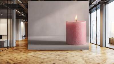 Photograph of a pink candle with a flickering flame against an isolated light gray background. Wall mural