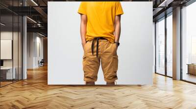 A man in yellow color casual outfit standing in the studio with isolated background Wall mural