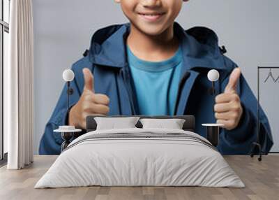 young Asian kid wearing a beige outfit is doing a thumb up, isolated on a white isolated background Wall mural