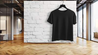 A sleek black tshirt is elegantly hanging on a hanger, beautifully set against a stylish brick wall backdrop Wall mural