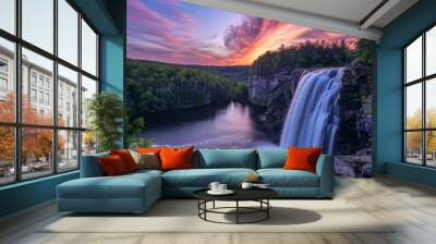 Beautiful sunset over a stunning waterfall flowing through a dense green forest, captured in vibrant colors. Wall mural