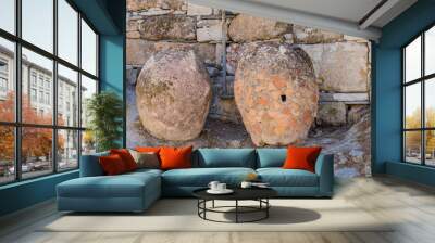 Two old earthenware jars stand beside a stone wall, showing signs of age and history, in Athens, Greece Wall mural