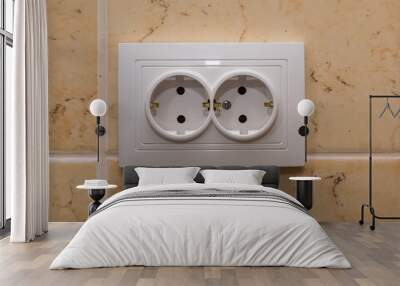 White electrical outlet with two sockets on the tiled wall. Wall mural