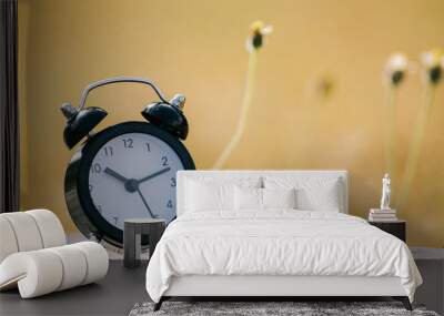 Vintage alarm clock on yellow background with bokeh Wall mural