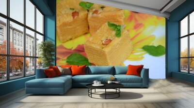 Closeup of the yellow gram flour sweets with green mint. Selected focus. Wall mural