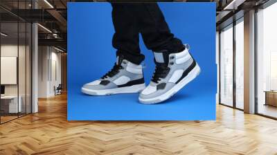 trendy white sneakers model shoot on the blue background Wall mural