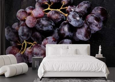 Bunch of black grapes isolated on black background Wall mural