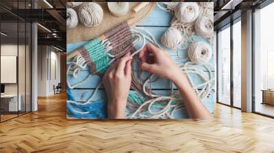 Hobby knitting macrame top view of the hand and thread on a wooden Board Wall mural