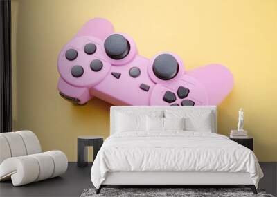 Pink video game controller, joystick for game console isolated on yellow background. Gamer control device close-up Wall mural