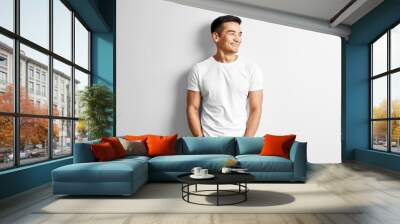 portrait of young asian designer dressed in casual against white wall. handsome kazakh man joyfully  Wall mural