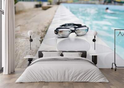 Close UP of black swimming goggles with a swimming pool background Wall mural