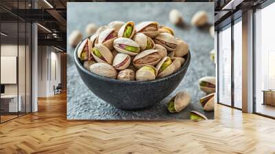 Delicious pistachios in bowl on grey textured table Wall mural