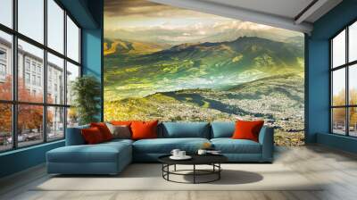 A breathtaking aerial view of Quito, Ecuador, nestled in the Andes mountains. The South American landscape showcases the iconic Cotopaxi volcano and vibrant streets. Wall mural