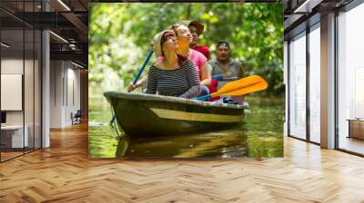 a group of tourists on a boat tour through the lush amazon rainforest, surrounded by exotic wildlife Wall mural