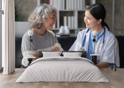 Asian female doctor examining a patient to assess the illness for proper treatment. Wall mural