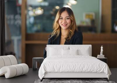 Beautiful young Asian business woman manager smiling looking at camera with crossed arms. Wall mural