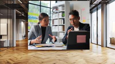 Business people having a discussion in the office, analyzing data on a digital tablet and brainstorming new project ideas Wall mural