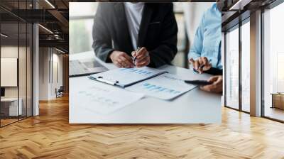 Business people meeting to plan the financial market looking at past quarterly company graph and chart to compare investment and analyze company revenue and marketing strategy. Wall mural