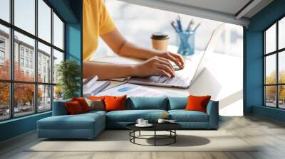 Businesswoman sitting using laptop computer with on the desk in the office. Wall mural