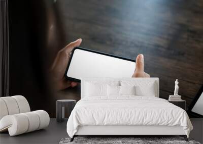 Close up shot of a woman holding a smartphone horizontally blank white screen. Mock up. Wall mural