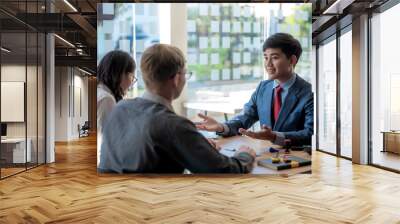 Investment broker or bank worker in suit consulting young couple in office. Wall mural