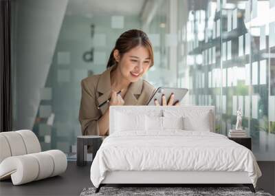 Pretty Asian businesswoman sitting on a laptop And the work came out successfully and the goal was achieved, happy and satisfied with her. Wall mural