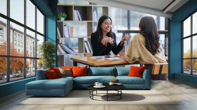 Two happy asian businesswoman talking and consulting working together in the office Wall mural