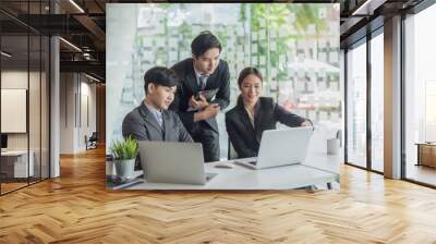 Young asian business people meeting and planning business strategies together in the office. Wall mural