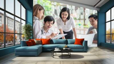 Young asian modern people in smart casual wear having meeting planning work together as a team and present ideas at work. Wall mural