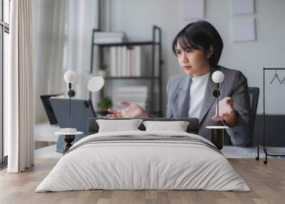 Young businesswoman is gesturing with frustration while participating in a video conference on her tablet Wall mural