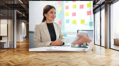 Young businesswoman is smiling during a meeting with a real estate agent in an office Wall mural