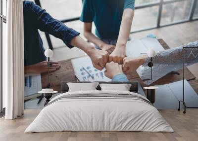 Young entrepreneurs work as a team meeting and work together on a new project that emphasizes unity and fist-pumping teamwork as a promise of unity in the workplace. Wall mural