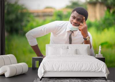 image of African guy, face mask lowered at his chin, with a scripture- bible reading concept Wall mural