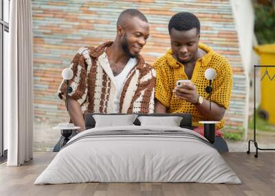 image of african guys with smartphone outside- two black guys wearing woven dress enjoying social media outdoor Wall mural