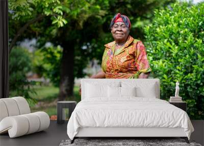 image of african old woman in a garden, holding a stick Wall mural