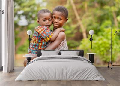 image of beautiful african siblings, young black girl carrying a young boy- outdoor concept Wall mural