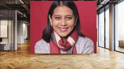 A Women with 25 years old looking at the camera with excited facial expression in front of the red background Wall mural