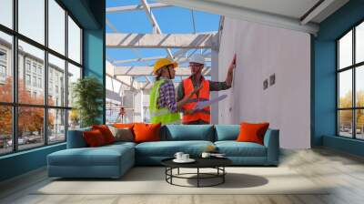 Caucasian engineer manager and foreman or leader discussion with woman engineering and pointing to construction site project on workplace . Teamwork, Leadership concept. Wall mural